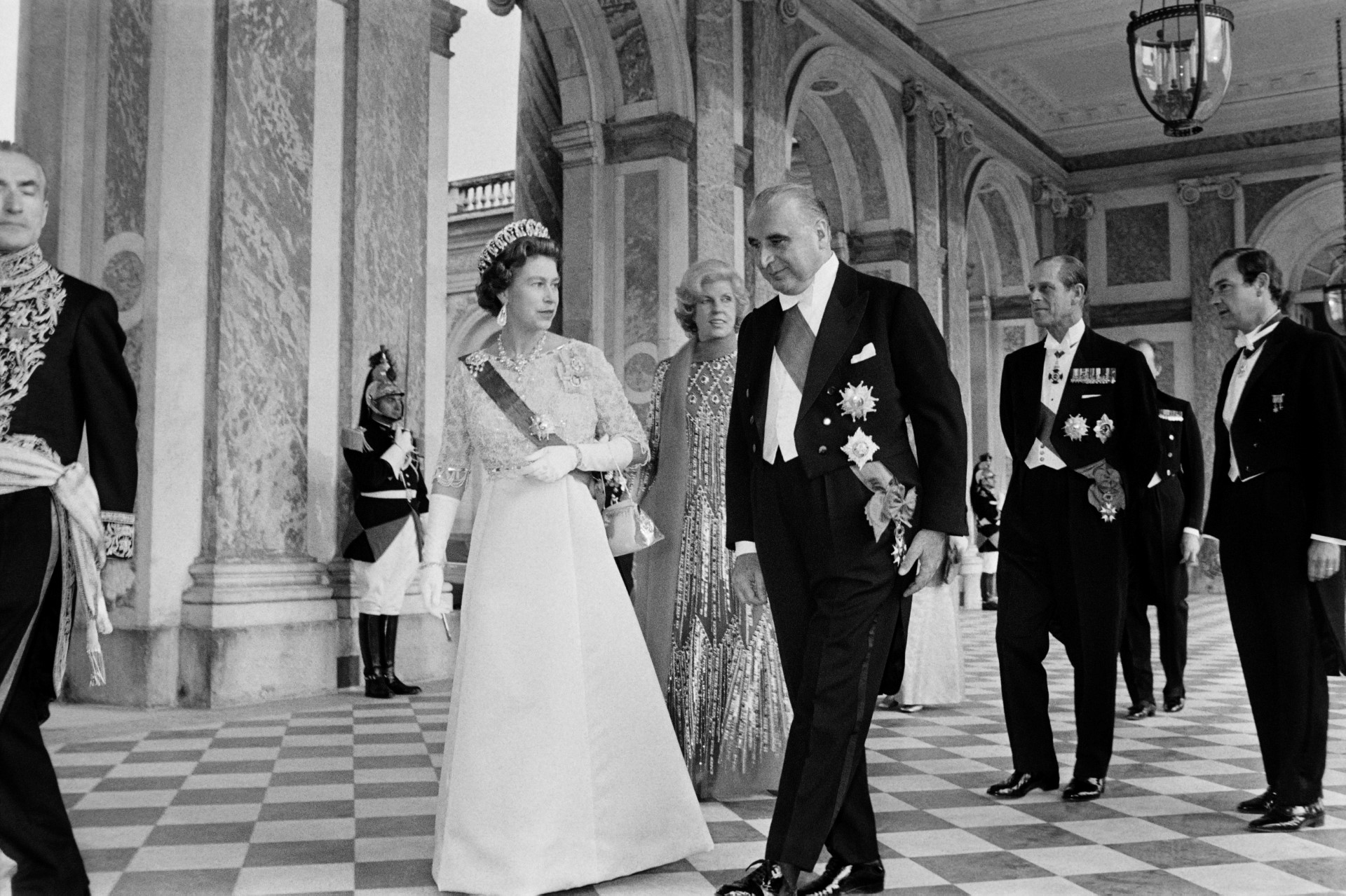 La reine Elizabeth II (à gauche), le prince Philip, duc d'Édimbourg (à l'arrière-plan), le président français Georges Pompidou (à gauche) et son épouse Claude (à l'arrière-plan) arrivent pour un dîner d'État au Grand Trianon de Versailles, le 15 mai 1972. (Photo de l'AFP)