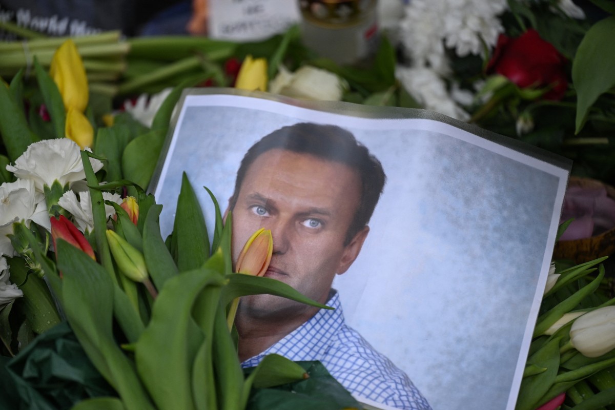 Des fleurs sont placées autour des portraits du défunt chef de l'opposition russe Alexei Navalny, décédé dans une prison russe de l'Arctique, sur un mémorial devant l'ancien consulat russe à Francfort-sur-le-Main, dans l'ouest de l'Allemagne, le 20 février 2024 (Photo, AFP).