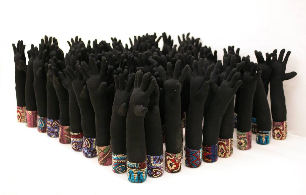 Maha Malluh, Sky Clouds, 2009-2015, 100 gants noirs en polyester remplis de polyester et de sables du désert, tapis de prière. (Avec l'aimable autorisation de la Galerie Krinzinger et de Maha Malluh)