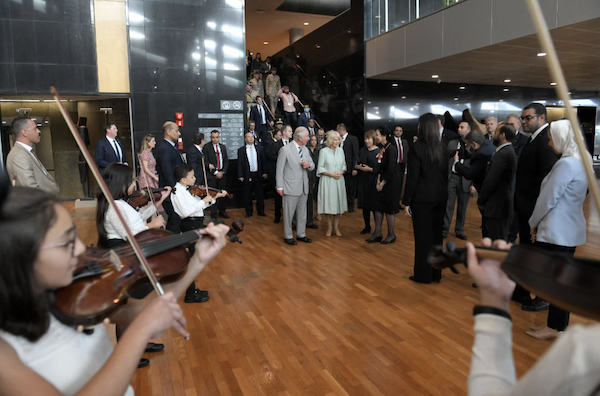 Le Prince Charles et son épouse Camilla accueillis par des officiels et un quatuor d'enfants alors qu'ils arrivent pour visiter la Bibliotheca Alexandrina, en Egypte, le 19 novembre 2021. (AFP)
