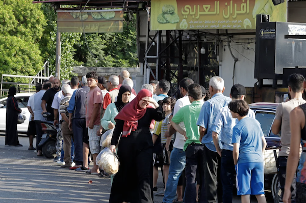 Des personnes faisant la queue devant une boulangerie pour acheter du pain dans la ville de Sidon (Saïda), dans le sud du Liban, le 22 juin 2022, alors que la pénurie de carburant et de blé s'aggrave. (AFP/File Photo)