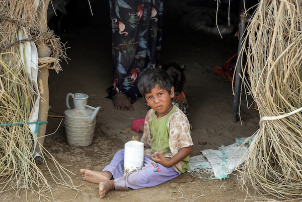 Un enfant assis à l'entrée d'un abri dans un camp de personnes déplacées endommagé par des pluies torrentielles dans le district de Jarrahi, dans la province occidentale de Hodeidah, au Yémen. (AFP)