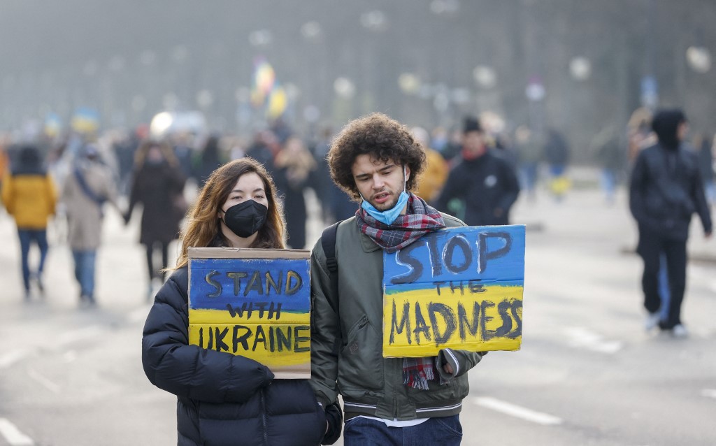 Des manifestants pour la paix en Ukraine portent une pancarte indiquant Stand with Ukraine et Stop the madness à Berlin e le 27 février 2022