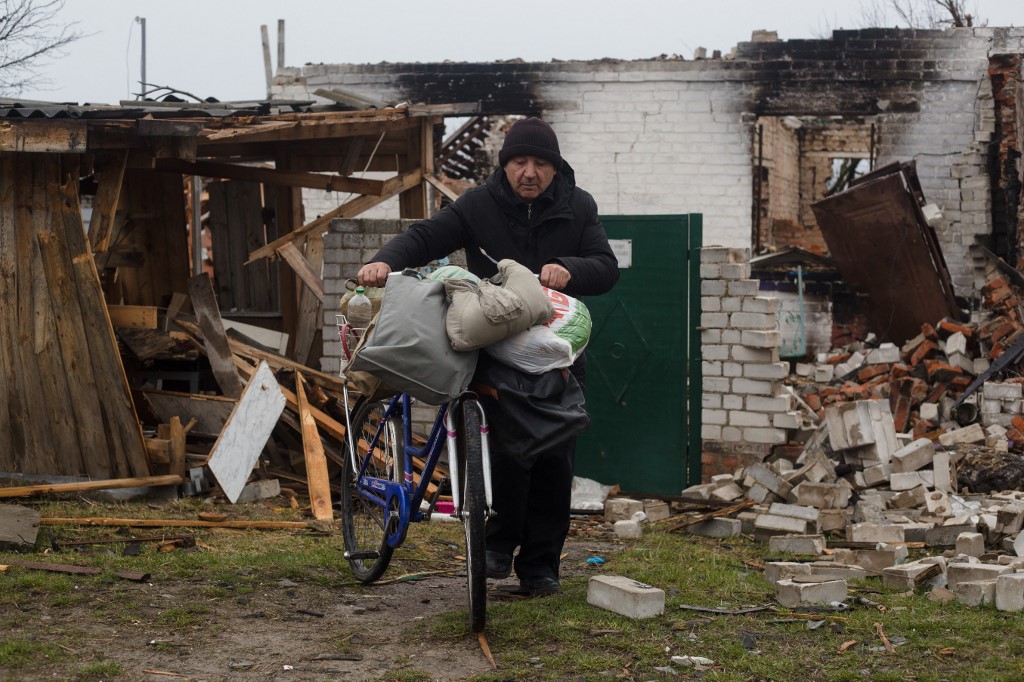 Mykola, un résident local, prend les objets de valeur de sa maison détruite à vélo le 9 avril 2022 à Novoselivka, dans la banlieue de Chernihiv, en Ukraine.