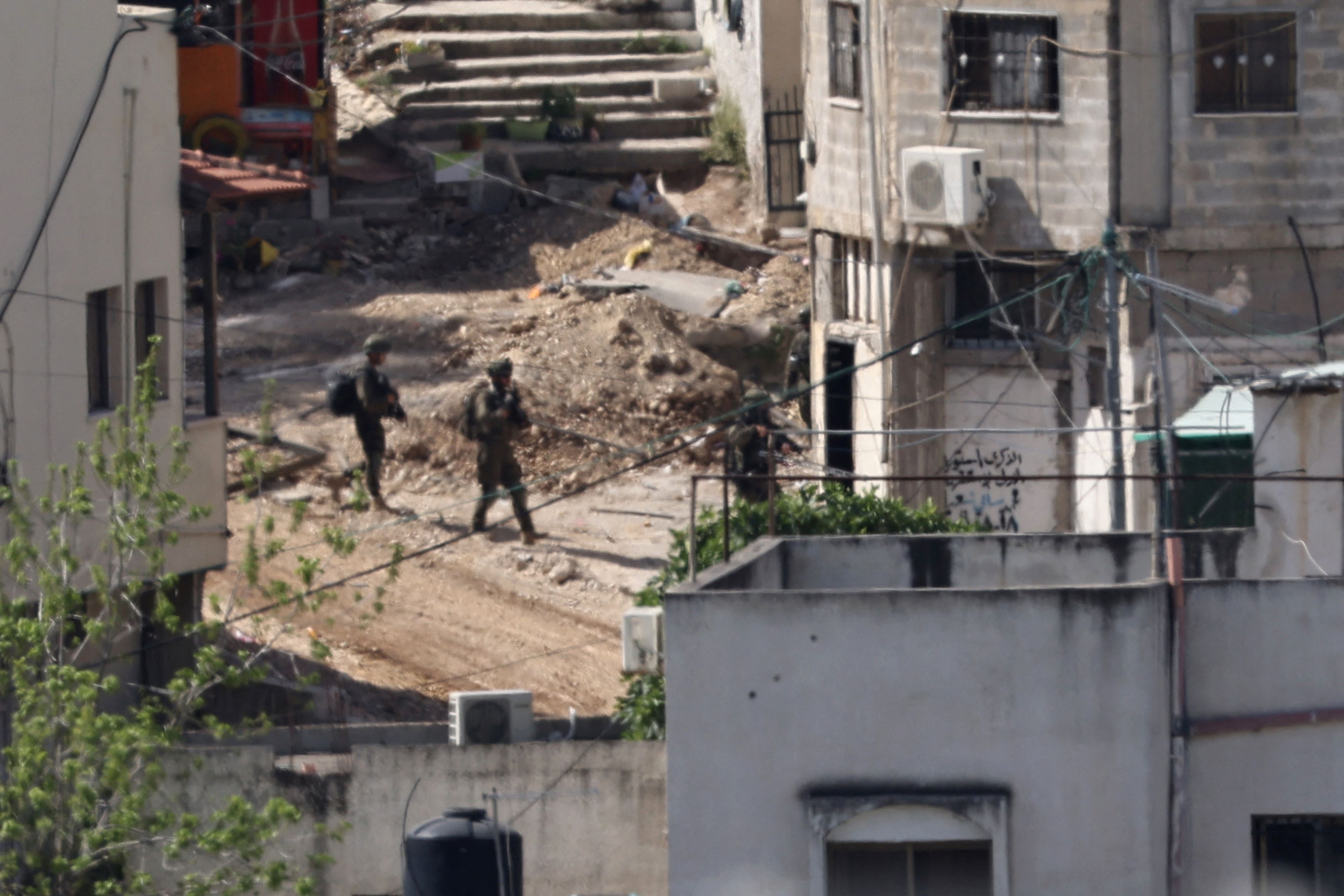 Des soldats israéliens encerclent une maison lors d'un raid dans le camp de réfugiés palestiniens de Nur Shams, en Cisjordanie occupée, le 20 avril 2024. (AFP)