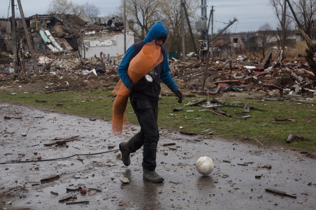 Un résident local marche avec un ballon dans le quartier résidentiel qui a été détruit à la suite d'un tir d'obus le 9 avril 2022 à Novoselivka, dans la banlieue de Tchernihiv, en Ukraine