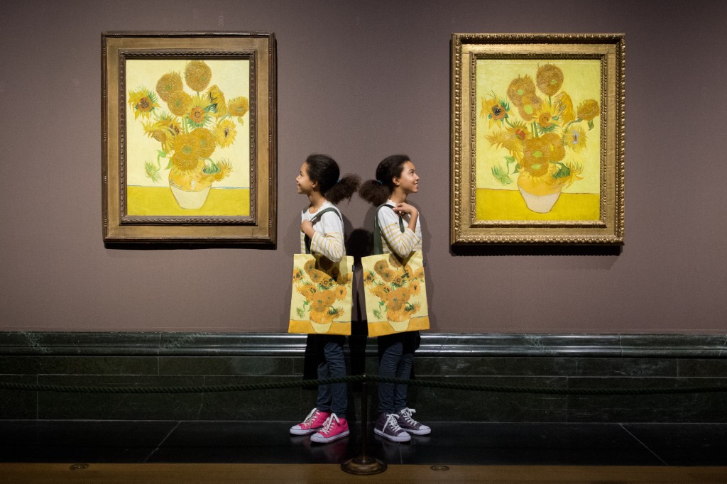  Les jumelles identiques Ella (à gauche) et Eva posent pour des photos avec deux versions des tableaux Tournesols de l'artiste néerlandais Vincent van Gogh à la National Gallery de Londres, le 24 janvier 2014. (Photo de Leon Neal / AFP)