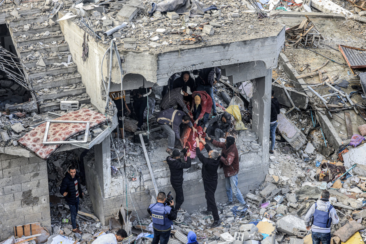 Des hommes récupèrent le corps d’une victime tuée lors d’une attaque israélienne sur le camp de réfugiés de Maghazi, le 25 décembre 2023. (AFP)