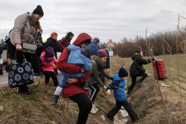 Des personnes fuyant l’invasion de l’Ukraine par la Russie marchent vers un hélicoptère de transport (non représenté sur la photo), après leur arrivée en Slovaquie le 5 mars 2022. (REUTERS)
