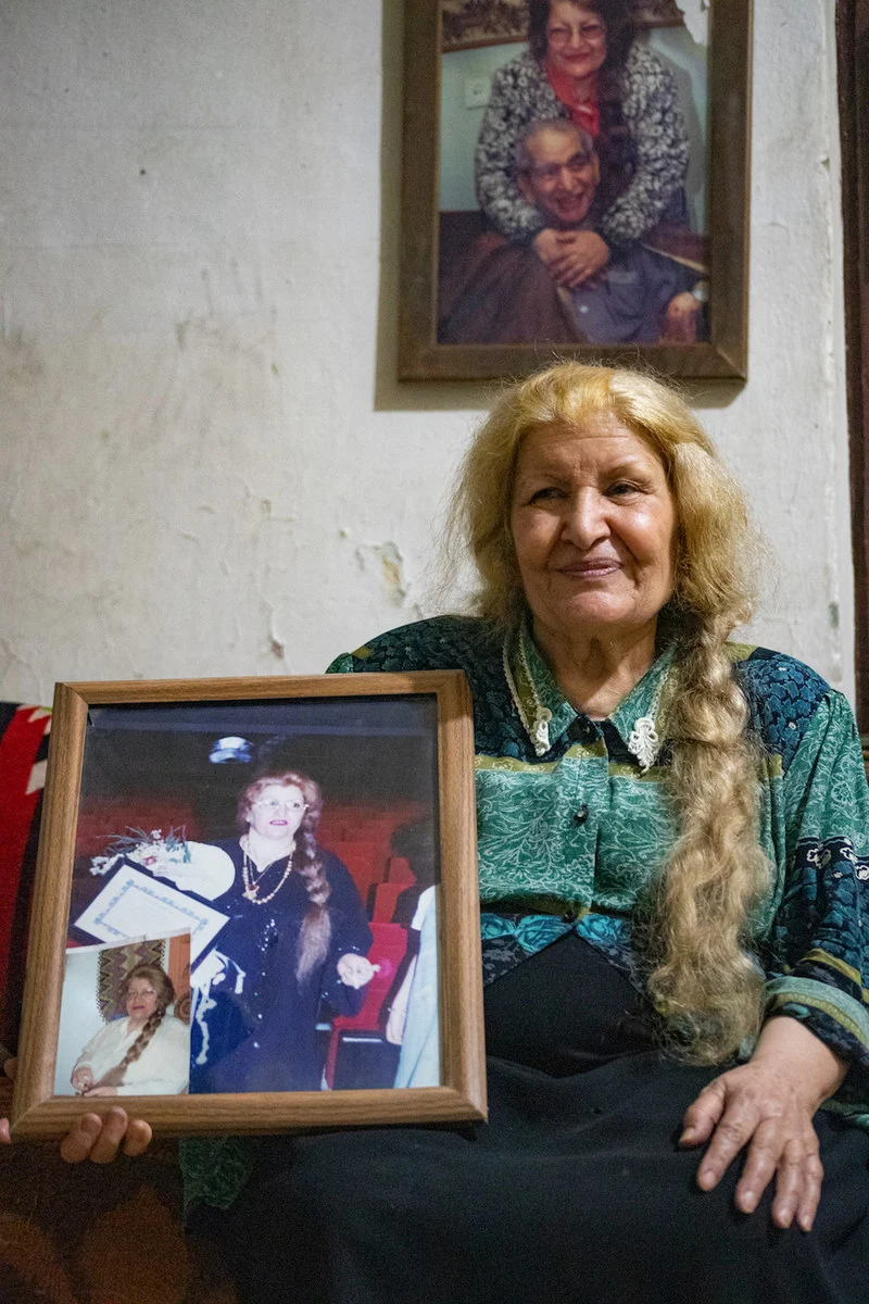 Writer Fawzia Al-Marai, 74, holds an old photo of herself, with the late Syrian poet Abd al-Salam al-Ajili in the background.  (Photo / Ali Ali)