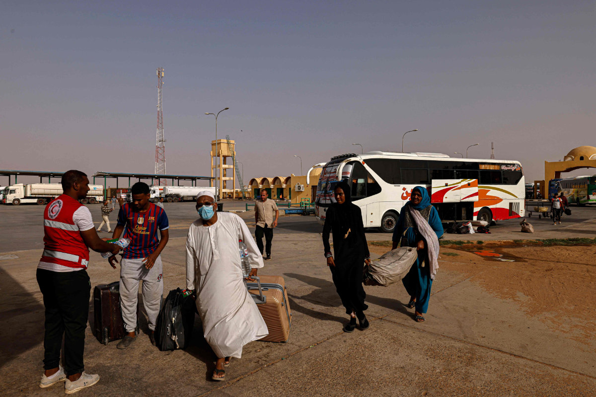 Des passagers fuyant le Soudan touché par la guerre entrent en Égypte par le port terrestre d’Argeen le 12 mai 2023. (AFP) 