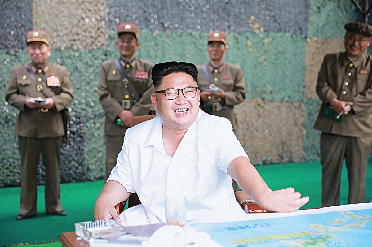 Le dirigeant nord-coréen Kim Jong-un (au centre) passe en revue un exercice de lancement de missiles balistiques par l'Armée populaire de Corée, le 21 juillet 2016. (KCNA via KNS/AFP)