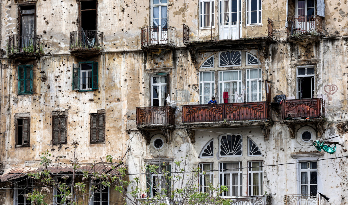 Un garçon se tient sur le balcon d’un immeuble ravagé par la guerre civile au Liban, dans le quartier de Ras al-Nabeh, à Beyrouth, le 13 avril 2023. (AFP)