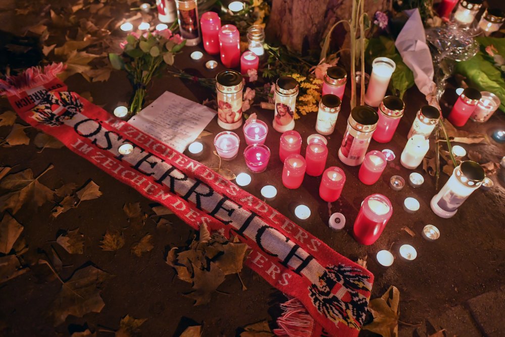 Des fleurs, des bougies et un foulard autrichien, déposés sur un site commémoratif à Vienne, en Autriche, le 3 novembre 2020, à l’endroit d'une attaque. La photo a été prise au lendemain de l’attentat au cours duquel des fusillades ont retenti, à plusieurs endroits, dans le centre de Vienne (Photo de Joe Klamar/AFP)
