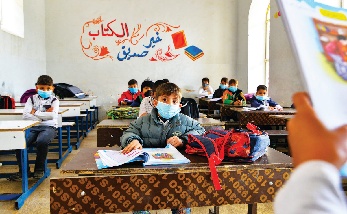 En Irak, des élèves portant des masques assistent aux cours le premier jour de la rentrée à Mossoul. (AFP)