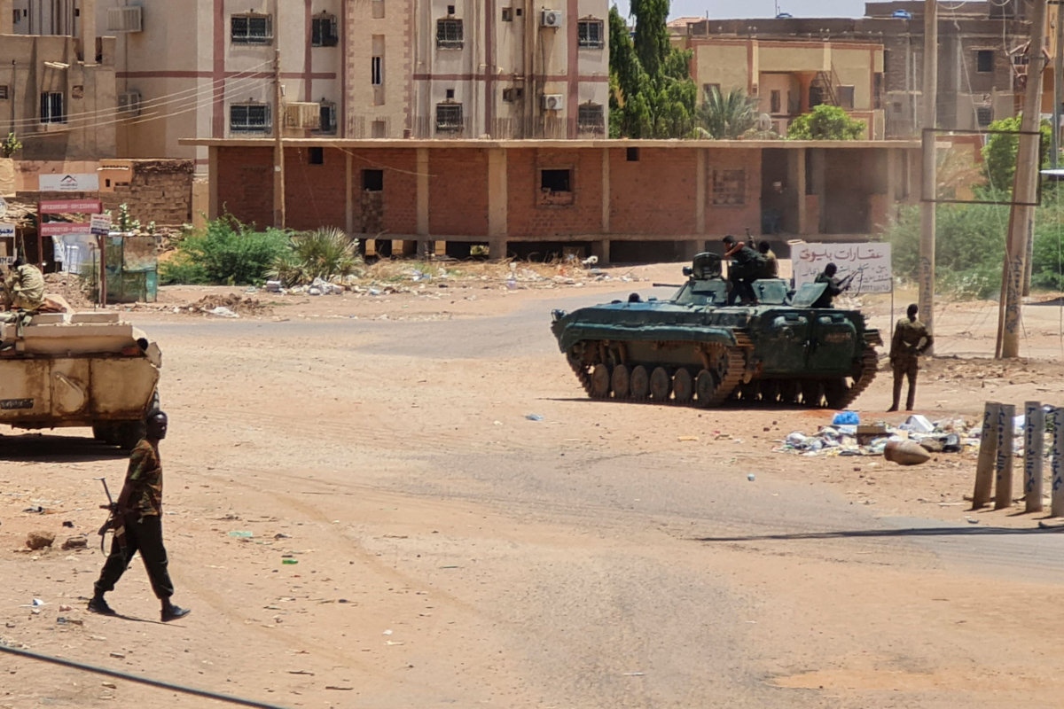 Des soldats de l’armée soudanaise marchent près de chars stationnés dans une rue du sud de Khartoum le 6 mai 2023, au milieu des combats en cours contre les forces paramilitaires de soutien rapide. (AFP)