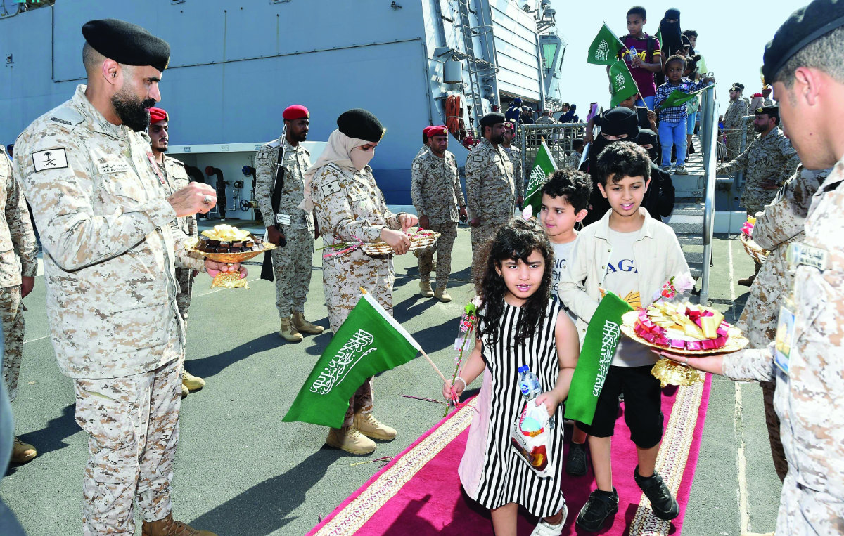 Les forces de sécurité saoudiennes accueillent des citoyens saoudiens et d'autres ressortissants avec des chocolats et des fleurs alors qu'ils débarquent à Djeddah d'un navire qui les a sauvés du Soudan. (SPA