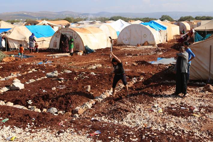 Sur cette photo, des Syriens travaillent dans un petit champ au sein d’un camp de réfugiés internes. (Photo publiée avec l’aimable autorisation de la FAO)