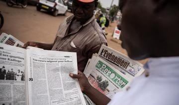 Un homme lit un article dans le journal L'Observateur Paalga à Ouagadougou le 7 juin 2021, sur les attentats survenus à Solhan (Photo, AFP) 