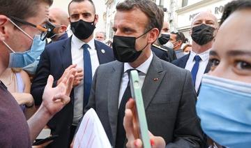 Le président français Emmanuel Macron s'entretient avec un jeune garçon alors qu'il marche dans une rue de Valence, le 8 juin 2021 (Photo, AFP)