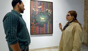 Un visiteur s'entretient avec l'artiste libyenne Elham el-Ferjani devant l'une de ses œuvres à la galerie Hamim de la ville orientale de Benghazi, le 14 juin 2021 (Photo, AFP)