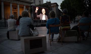 Les gens regardent une projection vidéo d'un concert sur la place de Verdun à Aix-en-Provence le 21 juillet 2020, dans le cadre de l'édition numérique pour l’année 2020 du Festival International d'Art Lyrique d'Aix-en-Provence. (Clément Mahoudeau/AFP)