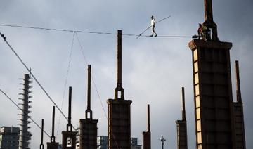 Le funambule italien Andrea Loreni sur une corde d'acier à 25 mètres de haut entre deux tours d'une usine du Parco Dora à Turin le 29 janvier 2021. (Marco Bertorello / AFP)