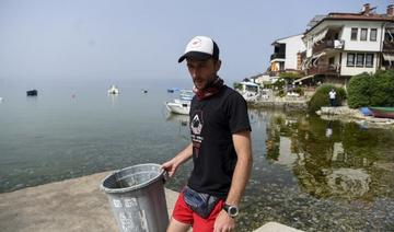 Le plongeur et archéologue Nikola Paskali collecte des déchets sur la plage de la vieille ville près des rives du lac d'Ohrid, au sud-ouest de la République de Macédoine du Nord, le 22 juin 2021. (Robert Atanasovski / AFP)