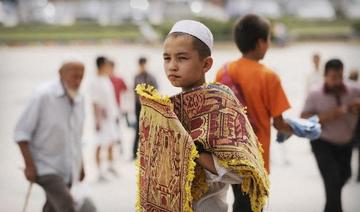 Un jeune ouïghour vend des tapis de prière devant la mosquée Id Kah le 8 août 2008 à Kashgar (Photo, AFP/ Archive)