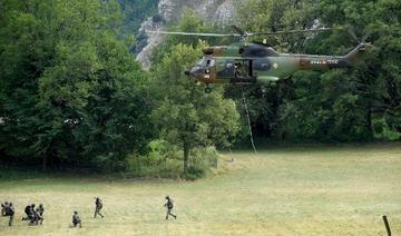Des membres du Groupe d'intervention de la gendarmerie nationale (GIGN) se tiennent dans un champ alors qu'un hélicoptère Puma de l'Armée de Terre française atterrit à Gréolières, dans le sud-est de la France, le 19 juillet 2021 (Photo, AFP)