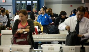 Les passagers déposent leurs effets personnels dans des poubelles avant de passer le contrôle de sécurité des passagers au terminal 8 de l'aéroport international John F. Kennedy le 22 octobre 2010. (Fichier/AFP)