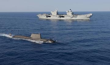 Travelling Sous-marin de la classe Astute en surface avec le porte-avion HMS Queen Elizabeth en arrière-plan (Photo, AFP)
