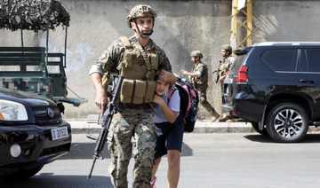 Un soldat aidant une écolière à rejoindre ses parents, après qu'une fusillade a éclaté à Beyrouth, le 14 octobre 2021. (Reuters) 