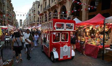 Un véhicule habillé comme un bus à deux étages roule près des participants au festival de la rue de Beyrouth, dans le centre-ville de Beyrouth, le 22 juin 2024. (Photo par Joseph EID / AFP)