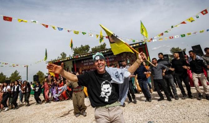 Un homme portant les couleurs du Parti des travailleurs du Kurdistan (PKK), Abdullah Ocalan, danse lors d'une célébration du deuxième jour de Norouz, le nouvel an persan, dans la province syrienne de Hasakah, près de la frontière avec la Turquie, le 21 mars 2021.(Delil Souleiman/AFP)