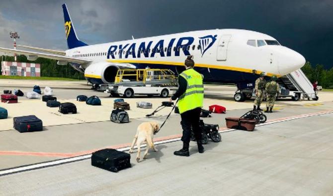 Un maître-chien biélorusse vérifie les bagages d'un Boeing de Ryanair stationné sur le tarmac de l'aéroport international de Minsk, le 23 mai 2021. (ONLINER.BY / AFP)