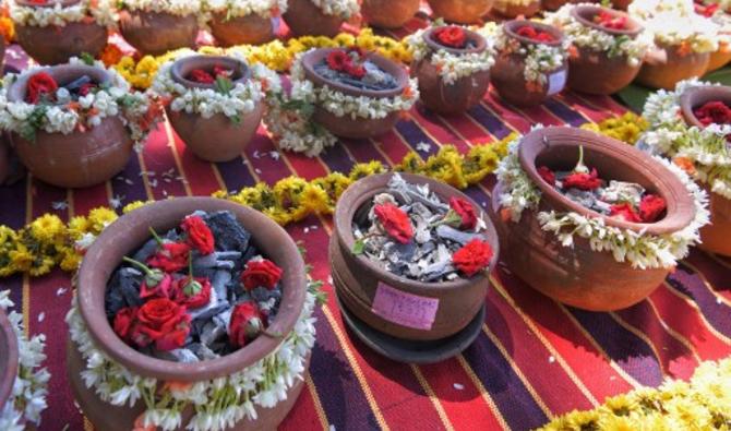 Couvertes d'une poignée de fleurs colorées et identifiées par une simple numéro, des dizaines d'urnes en argile contenant les cendres de plus de 1 200 victimes de la Covid-19 dont personne n'est venu réclamer les corps, ont été immergées au cours d'une cérémonie hindouiste près de Bangalore, dans le sud de l'Inde, le 2 juin 2021 (Photo, AFP)