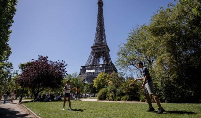 Des enfants jouent par un après-midi ensoleillé, dans le parc du Champs de Mars, alors que la Tour Eiffel est vue en arrière-plan, à Paris, le 13 juin 2021 (Photo, AFP)