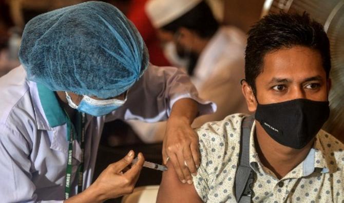Un agent de santé inocule à un patient une dose du vaccin Oxford-AstraZeneca Covid-19 au Bangabandhu Sheikh Mujib Medical University Hospital (BSMMU), à Dhaka le 22 juin 2021. (Munir Uzzaman/AFP)