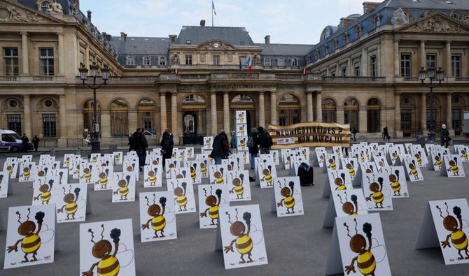 Des militants de l'ONG écologiste "la Confédération paysanne" ont installé des pancartes montrant un dessin d'une abeille en colère devant le Conseil d'État à Paris. (AFP/Archives)