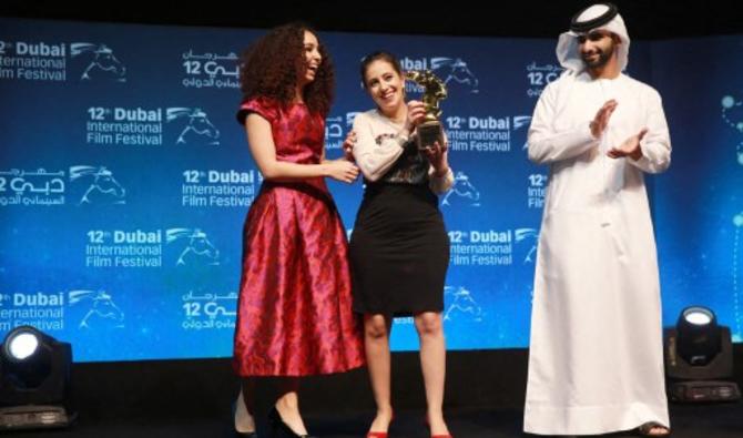 La réalisatrice tunisienne Leyla Bouzid (C) reçoit le prix Muhr de la meilleure fiction des mains du cheikh Mansoor bin Mohammed bin Rashid al-Maktoum lors de la cérémonie de clôture du Festival international du film de Dubaï le 16 décembre 2015 pour son film intitulé "Comme j'ouvre les yeux". (AFP/ STR)