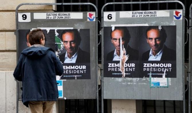 Un homme s'arrête devant des pancartes en faveur d'une candidature du spécialiste des médias d'extrême droite français Eric Zemmour aux élections présidentielles à Paris le 29 juin 2021 (Photo, AFP)