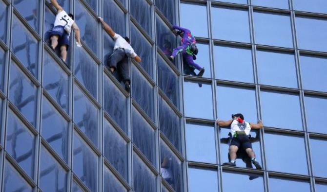 Alain Robert, surnommé le «Spider-Man français», a escaladé mardi à mains nues une tour du quartier d'affaires de La Défense (Hauts-de-Seine), en lisière de Paris, pour marquer son opposition au pass sanitaire (Photo, AFP)