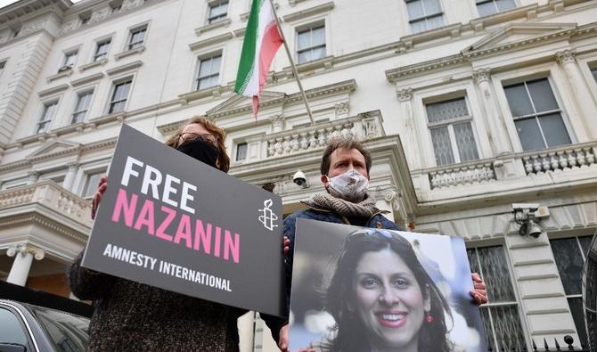 Richard Ratcliffe, époux de Nazanin Zaghari-Ratcliffe, l’Anglo-iranienne qui travaille avec une association humanitaire tenant une photo de sa femme devant l'ambassade d'Iran à Londres (Dossier/AFP) 