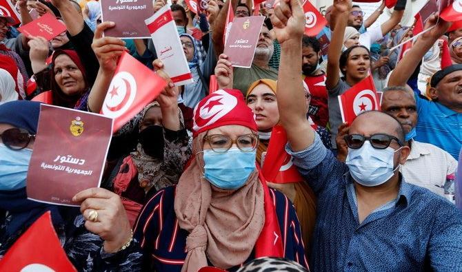 Des manifestants brandissent des drapeaux et des copies de la constitution tunisienne lors d'une manifestation contre la mainmise du président tunisien Kais Saied le 26 septembre 2021(Reuters) 