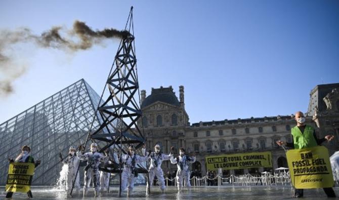 Ces militants, vêtus de combinaison portées sur les plateformes pétrolières, ont dressé un puits de pétrole factice de plusieurs mètres de haut dans une fontaine de l'esplanade du Louvre et installé une banderole avec le slogan «Climat: Total criminel, le Louvre complice» (Photo, AFP)