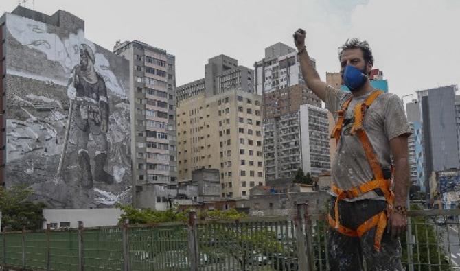 Après avoir recueilli 200 kg de cendres dans différents biomes ravagés par les flammes, l'artiste a créé une immense fresque de 1 000 m2 sur un immeuble tout proche de l'Avenida Paulista, artère du coeur de la mégalopole brésilienne (Photo, AFP)