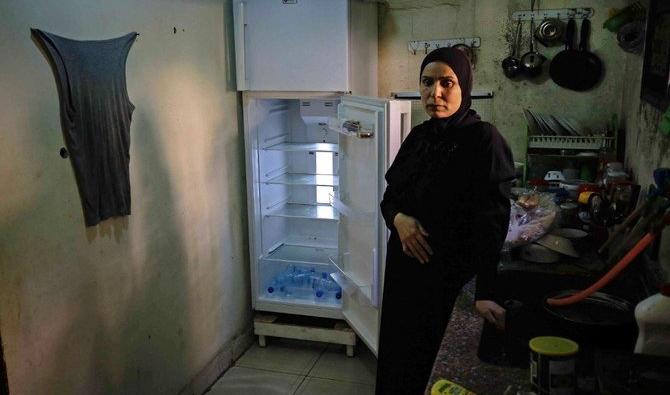 Une Libanaise à côté de son réfrigérateur vide dans son appartement de la ville portuaire de Tripoli, au nord de Beyrouth. (Dossier/AFP) 