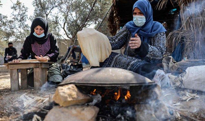 Des femmes préparent du pain dans un champ à Khan Younis, dans le sud de la bande de Gaza (Photo, AFP) 