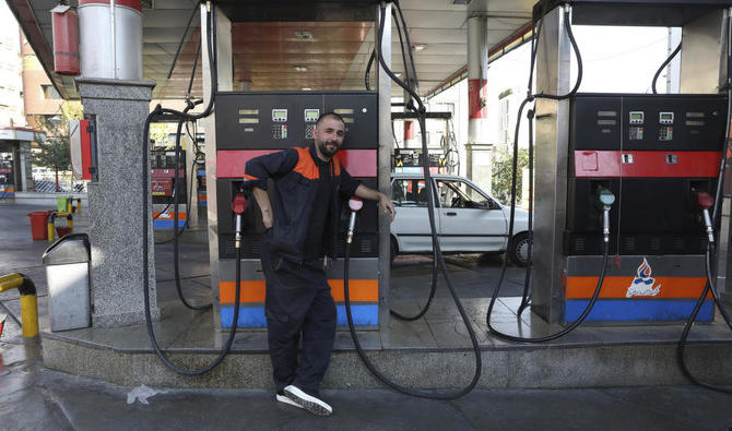 Un ouvrier s’appuie sur une pompe à essence dans une station-service de Téhéran qui a été fermée après la panne généralisée d’un système permettant aux consommateurs d’acheter du carburant avec une carte émise par le gouvernement, causant l’arrêt des ventes. (AP) 